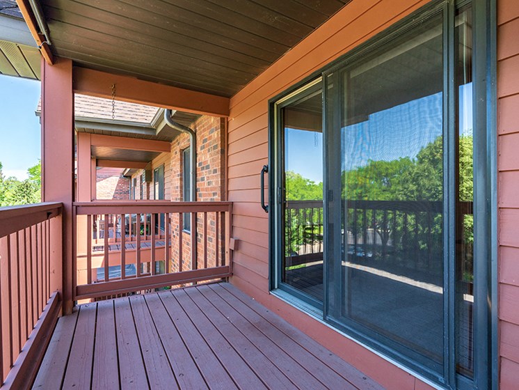 Maroon colored wooden deck and a sliding glass door